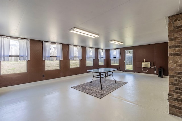 rec room featuring an AC wall unit and concrete flooring