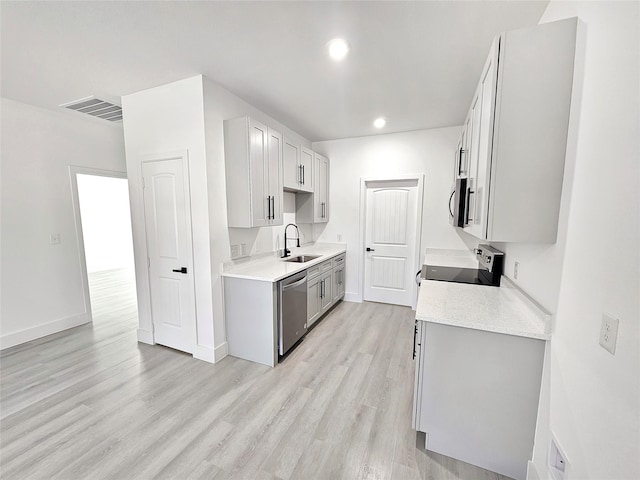 kitchen with sink, stainless steel appliances, light hardwood / wood-style floors, and light stone counters