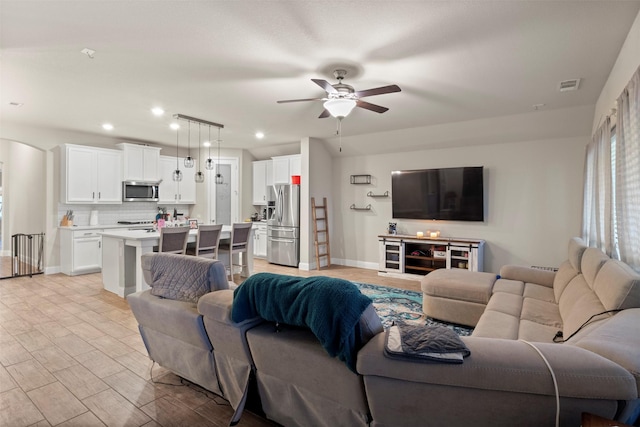 living room featuring light wood-type flooring and ceiling fan