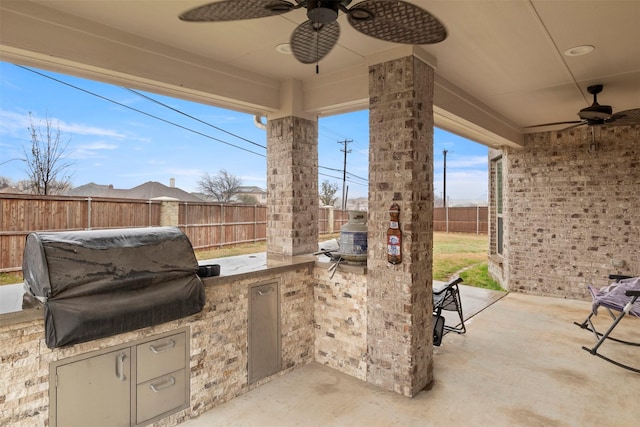 view of patio with ceiling fan, an outdoor kitchen, and a grill