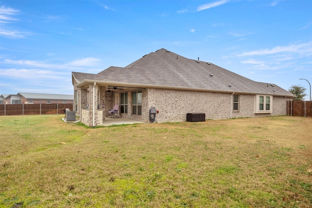 back of property featuring a patio area, cooling unit, and a lawn