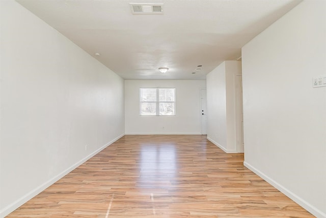 spare room featuring light wood-style floors, baseboards, and visible vents