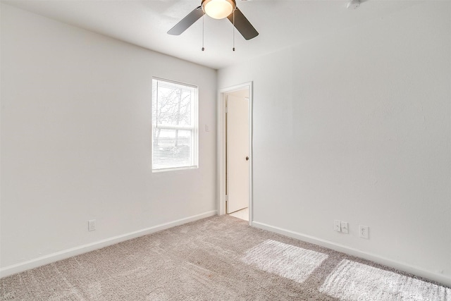 unfurnished room with light carpet, baseboards, and a ceiling fan