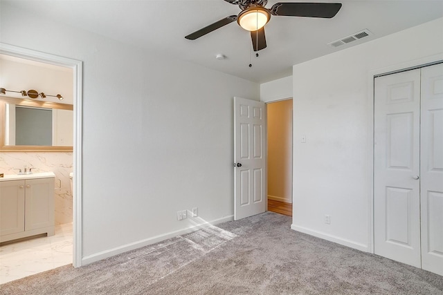 unfurnished bedroom featuring baseboards, a closet, visible vents, and light colored carpet