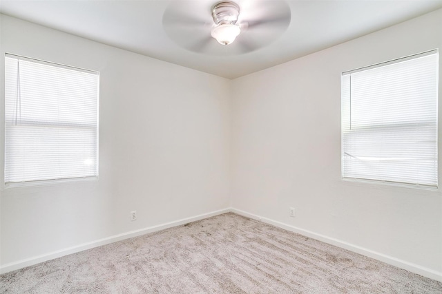 unfurnished room with light carpet, baseboards, and a ceiling fan