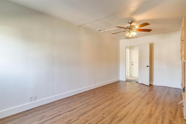 empty room featuring light wood finished floors, baseboards, visible vents, and a ceiling fan