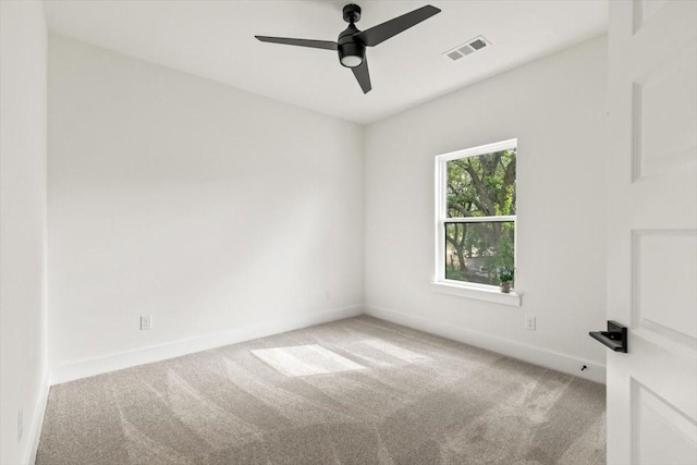 empty room featuring light carpet, ceiling fan, visible vents, and baseboards