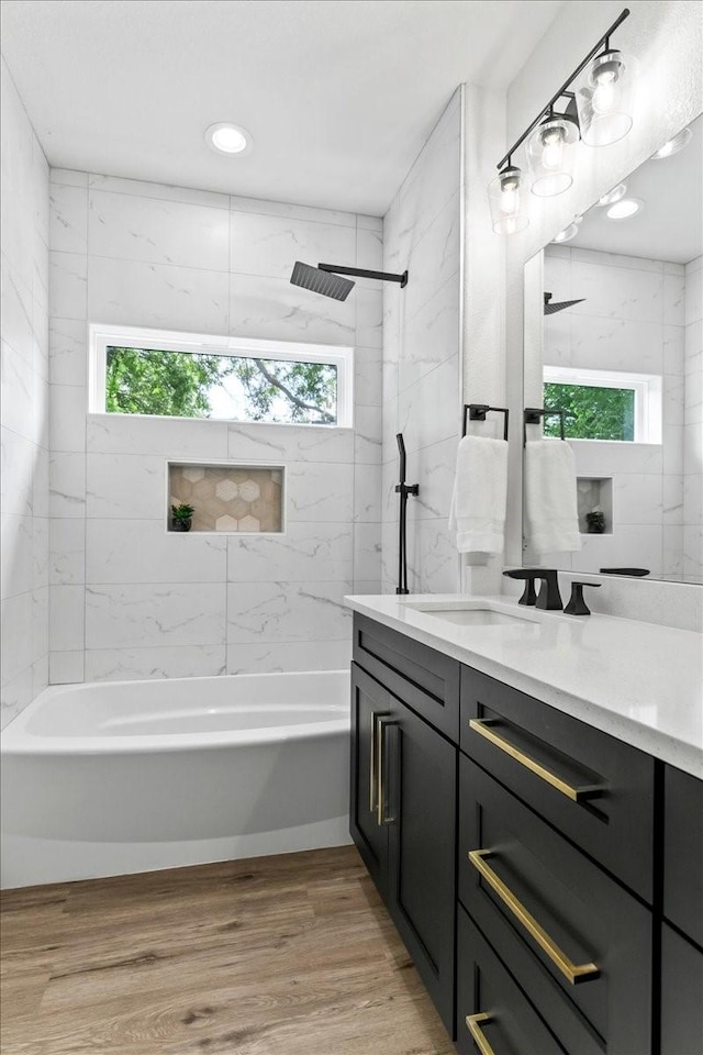 bathroom with bathtub / shower combination, wood finished floors, and vanity