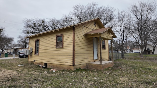 view of home's exterior featuring a lawn and fence