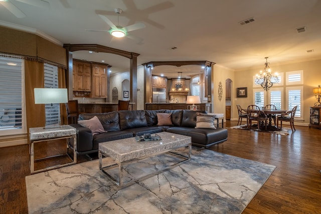 living room featuring ceiling fan with notable chandelier, ornamental molding, and wood-type flooring