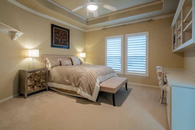 carpeted bedroom with a tray ceiling, ornamental molding, and ceiling fan