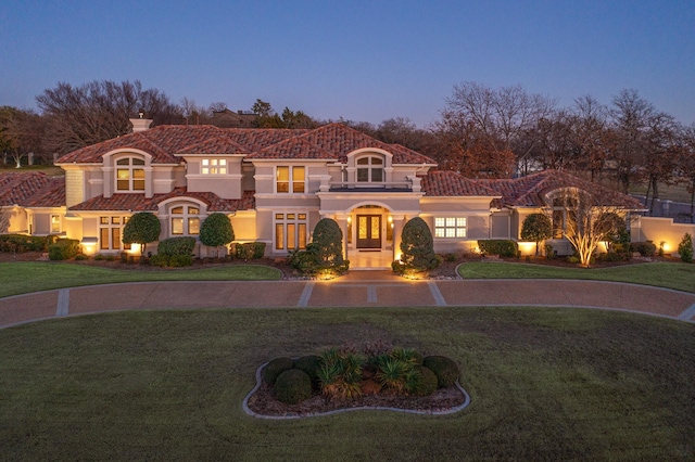 mediterranean / spanish-style home with french doors and a lawn