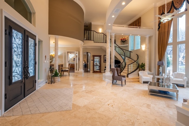 foyer with decorative columns, french doors, and a high ceiling