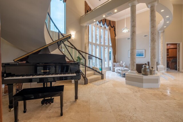 interior space with decorative columns, a high ceiling, and ornamental molding