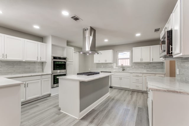 kitchen with white cabinetry, sink, island exhaust hood, and stainless steel appliances