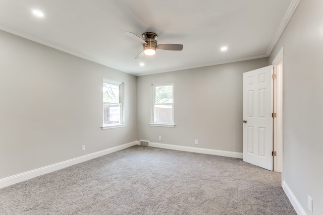 carpeted spare room with ceiling fan and ornamental molding