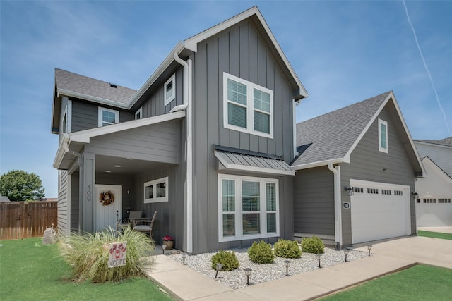 view of front of property with a garage, a shingled roof, a standing seam roof, fence, and board and batten siding