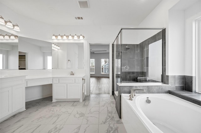 bathroom with vanity and shower with separate bathtub