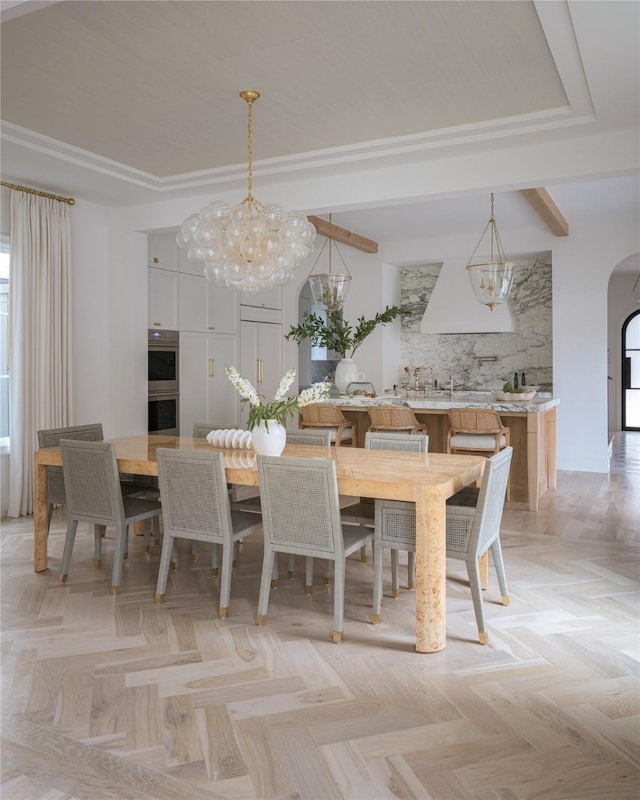 unfurnished dining area with a notable chandelier, beam ceiling, and light parquet flooring