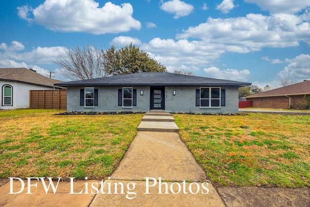 ranch-style house with a front yard, fence, and brick siding