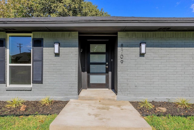 property entrance featuring brick siding