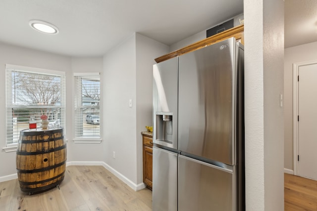 kitchen with light wood-type flooring and stainless steel fridge