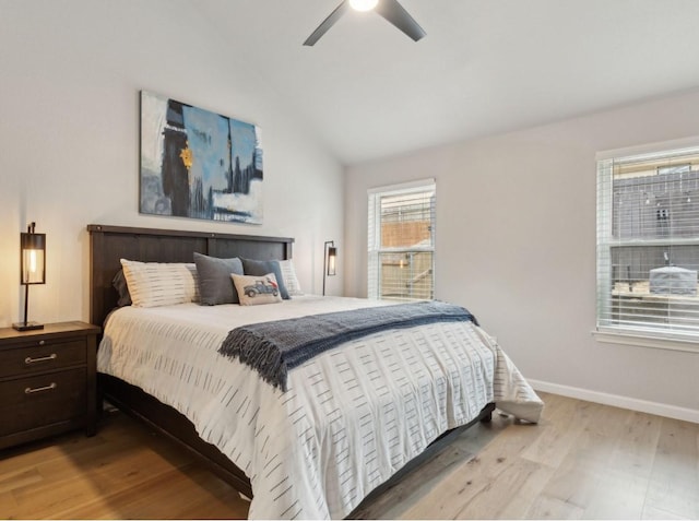 bedroom with ceiling fan, light hardwood / wood-style floors, and lofted ceiling