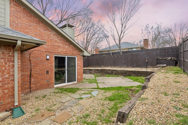 yard at dusk featuring a patio