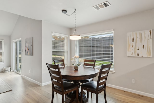 dining room with hardwood / wood-style flooring and lofted ceiling