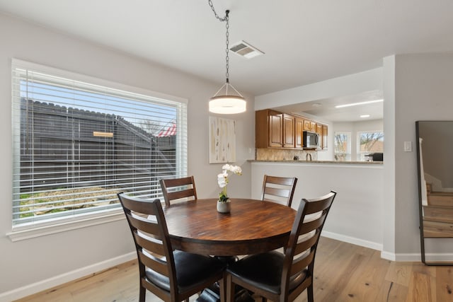 dining space with light wood-type flooring and plenty of natural light