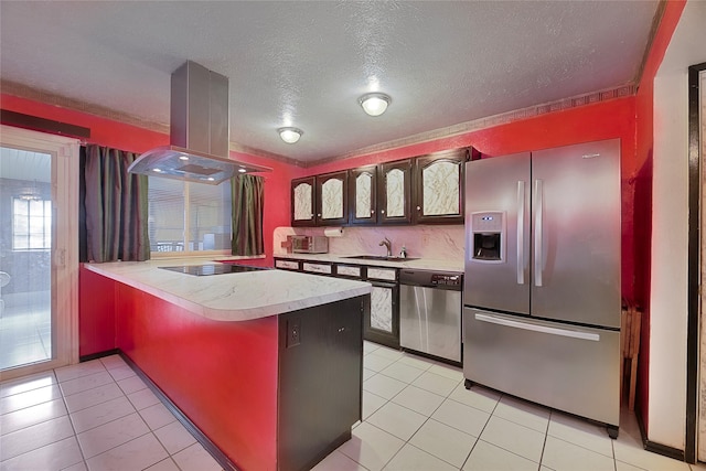 kitchen with island exhaust hood, stainless steel appliances, light countertops, a sink, and a peninsula