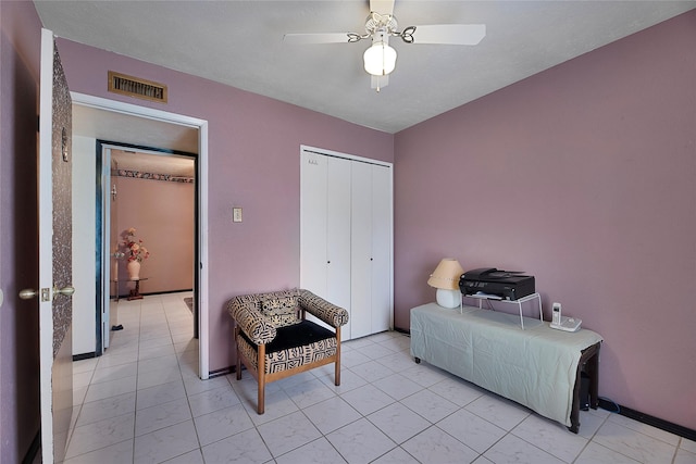 interior space featuring baseboards, visible vents, and a ceiling fan