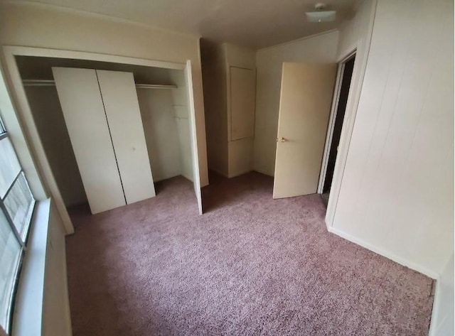 unfurnished bedroom with a closet and light colored carpet