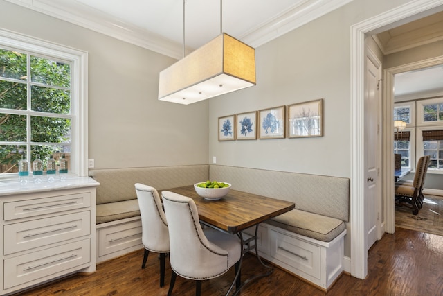 dining room featuring crown molding, breakfast area, and dark wood-type flooring