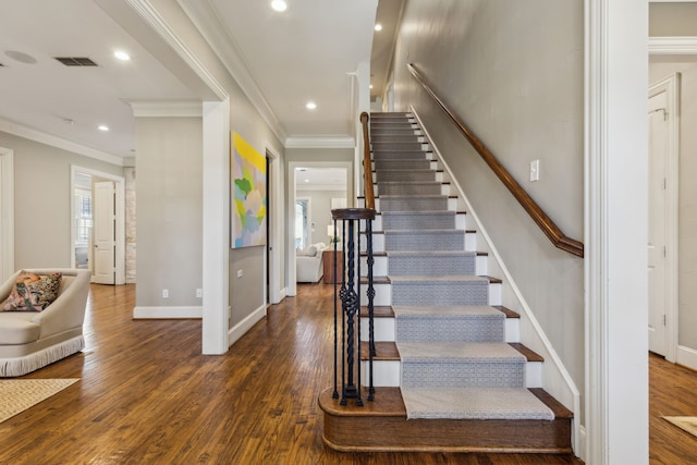 stairs featuring hardwood / wood-style floors and ornamental molding