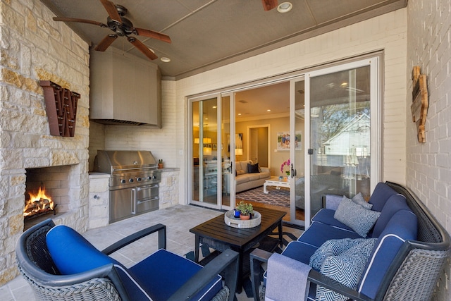 view of patio featuring ceiling fan, an outdoor stone fireplace, area for grilling, and exterior kitchen