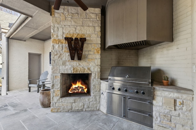 view of patio / terrace featuring area for grilling, a grill, and an outdoor stone fireplace