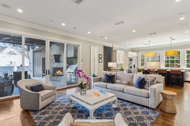 living room featuring hardwood / wood-style flooring, ornamental molding, and a premium fireplace