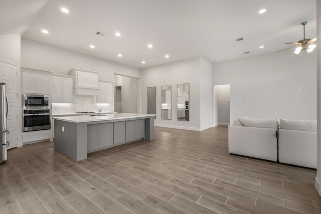 5716 Turner May Dr, Fort Worth, TX 76126 - kitchen featuring appliances with stainless steel finishes, open floor plan, light countertops, a center island with sink, and white cabinetry