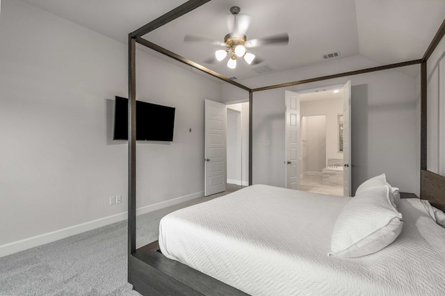 carpeted bedroom with ensuite bathroom and ceiling fan