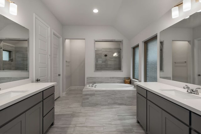 5716 Turner May Dr, Fort Worth, TX 76126 - bathroom with two vanities, a bath, marble look tile flooring, lofted ceiling, and recessed lighting