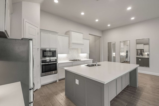 5716 Turner May Dr, Fort Worth, TX 76126 - kitchen featuring appliances with stainless steel finishes, wood finished floors, an island with sink, a sink, and backsplash