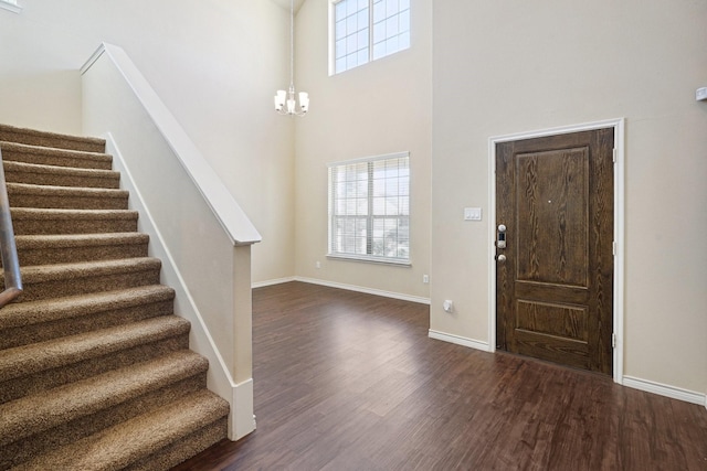 foyer featuring a high ceiling, a notable chandelier, and dark hardwood / wood-style flooring