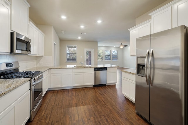 kitchen featuring white cabinets, appliances with stainless steel finishes, sink, and kitchen peninsula