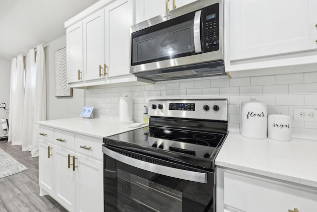 kitchen featuring white cabinetry, tasteful backsplash, stainless steel appliances, and light hardwood / wood-style floors