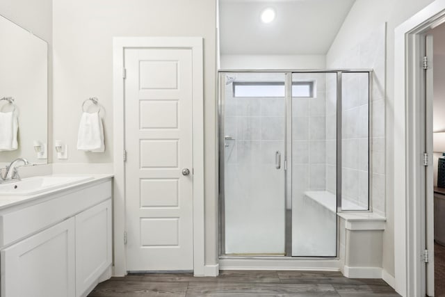 bathroom featuring hardwood / wood-style flooring, an enclosed shower, and vanity