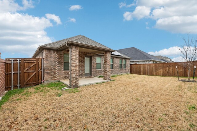 rear view of property with a patio and a yard