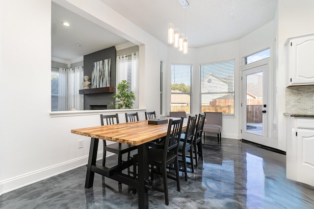 dining area featuring finished concrete floors, baseboards, and recessed lighting