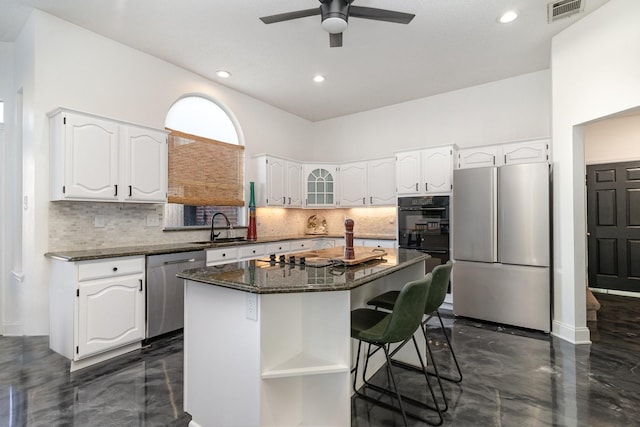 kitchen featuring appliances with stainless steel finishes, a kitchen island, visible vents, and white cabinets