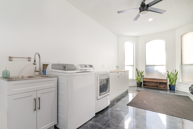 washroom with cabinet space, washer and clothes dryer, ceiling fan, a textured ceiling, and a sink